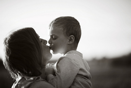 Black and white picture of mother kissing child in a healthy parent child relationship