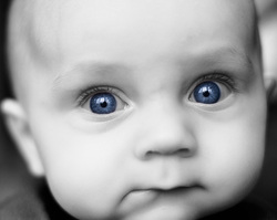 beautiful infant with bright blue eyes staring blankly as if affected by autism
